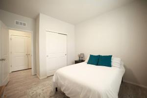 a bedroom with a white bed with a blue pillow at Lovely 2BR Home - Your Fort Collins Retreat! in Buckingham