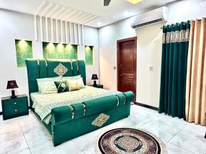 a bedroom with a green bed and green curtains at Homely Guest House in Rawalpindi