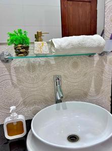 a white sink in a bathroom with a counter at Homely Guest House in Rawalpindi
