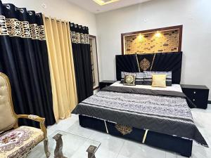 a bedroom with a bed with black and gold curtains at Homely Guest House in Rawalpindi