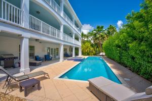 a swimming pool in the backyard of a house at Oceanside Manor- Expansive Waterfront Pool Home, 30' Dock in Key Colony Beach