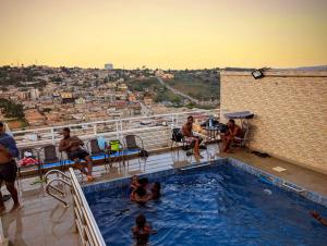 a group of people sitting around a swimming pool at COFE Hotel in Yaoundé