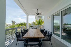 a table on a balcony with chairs and a ceiling fan at Paraiso Del Mar - Luxury Waterfront Pool Home, 65' Dock in Marathon