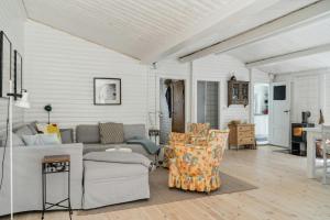 een woonkamer met een bank en stoelen bij Classic 1937 Cottage On A Natural Plot in Nykøbing Sjælland