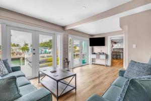 a living room with two couches and a table at Reel Deal - Waterfront Pool Home, 76' Dock in Marathon