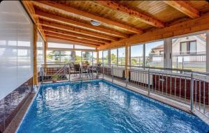 a large indoor swimming pool with a wooden ceiling at Villa Ana Selce s bazenom i panoramskim pogledom na more in Selce