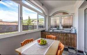 a kitchen with a table with a bowl of fruit on it at Villa Ana Selce s bazenom i panoramskim pogledom na more in Selce