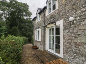ein Steinhaus mit einem großen Fenster an der Seite in der Unterkunft Wren Cottage in Ross on Wye