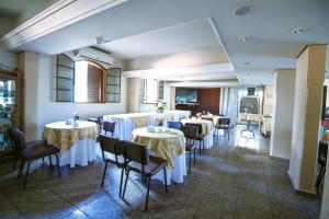 a dining room with tables and chairs and a room with tables and chairsktop at Piloes Palace Hotel in Mineiros