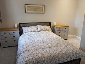 a bedroom with a bed and two night stands at The Roost at The Gables Farm in Poynton