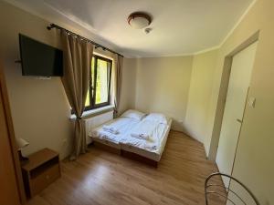 a small bedroom with a bed and a window at Zacisze in Zwardoń