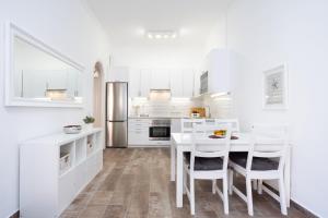 a kitchen with white cabinets and a table and chairs at Romantic Retreat in Prime Position in Acantilado de los Gigantes