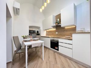 a kitchen with a white table and chairs in a room at Eden Suite Apartaments in Molfetta
