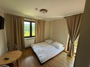 a small bedroom with a bed and a window at Zacisze in Zwardoń