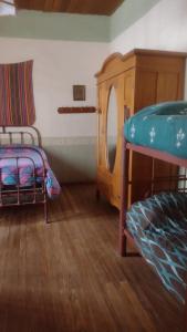 a bedroom with a bunk bed and a wooden cabinet at La Maison Enchantee in Humahuaca