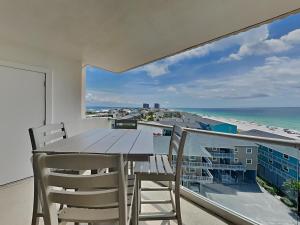 a balcony with a table and chairs and a view of the beach at Regency Towers #802 East in Pensacola Beach