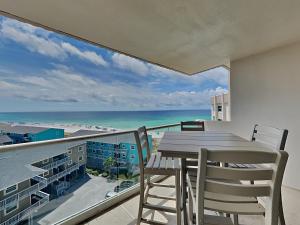 a balcony with a table and chairs and the ocean at Regency Towers #802 East in Pensacola Beach