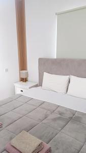 a bedroom with a large white bed with a nightstand at Spacious 2 BR appartment near mall -Internet 1Gbps in Paphos City
