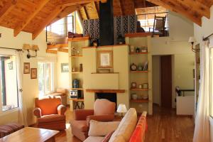 una sala de estar con un sofá y sillas en Ventanas Al Lago, en San Carlos de Bariloche