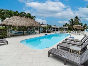 a swimming pool with chaise lounge chairs and a resort at Refuge on the Reef - Luxury Waterfront Pool Home, 75' Dpck in Marathon