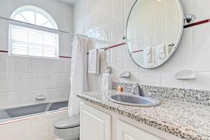 Un baño blanco con lavabo y espejo. en Reel Relaxin` - Luxury Waterfront Pool Home, 55' Dock, en Marathon 32 fotos más