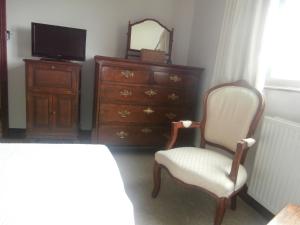 ein Schlafzimmer mit einer Kommode, einem Stuhl und einem Spiegel in der Unterkunft Highfield in Hay-on-Wye