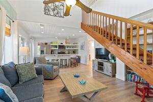 a living room with a couch and a staircase at Sea Haven - Waterfront Pool Home, 35' Dock, Steps From Sombrero Beach in Marathon