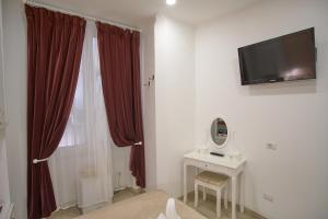 a room with a television and a table with a mirror at Museum Guest House in Civitavecchia