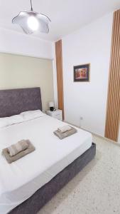 a bedroom with a white bed with two towels on it at Modern 2bd appartment near mall- Internet 1Gbps in Paphos