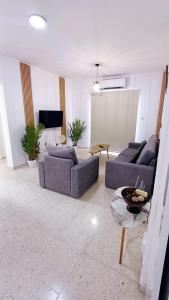 a living room with two couches and a table at Modern 2bd appartment near mall- Internet 1Gbps in Paphos