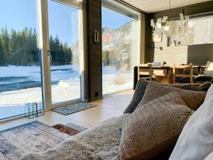 een woonkamer met een bank en een groot raam bij Hytte Ved Heimsila I Hemsedal in Hemsedal