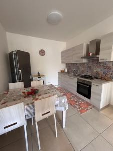 a kitchen with a table and chairs and a stove at Case del Mare - Corallo, Perla, Acquamarina in Terracina