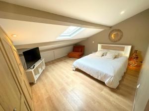 a bedroom with a white bed and a television at Superbe appartement moderne in La Valette-du-Var