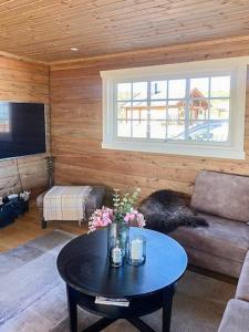 a living room with a couch and a table at Family Cabin At Blefjell in Lampeland
