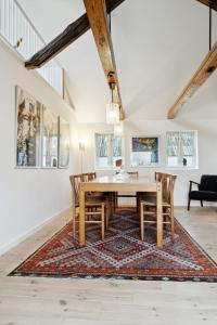 a dining room with a wooden table and chairs on a rug at Renovated Estate With Private Beach in Roslev +32 photos