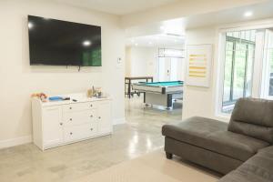 a living room with a couch and a pool table at Chalet Oasis - Spa and Incredible view in Saint-Philémon +35 photos