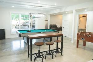a living room with a pool table and two stools at Chalet Oasis - Spa and Incredible view in Saint-Philémon