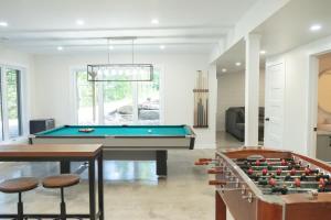 a living room with a pool table and two stools at Chalet Oasis - Spa and Incredible view in Saint-Philémon