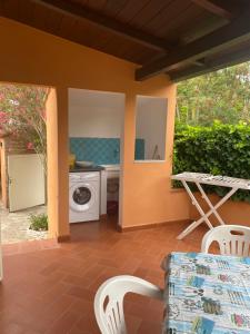 a patio with a washing machine and a table and chairs at Appartamenti Anna in Rio Marina