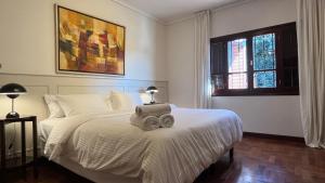 a bedroom with a white bed with two towels on it at CasaCharcas Hotel Boutique in San Salvador de Jujuy