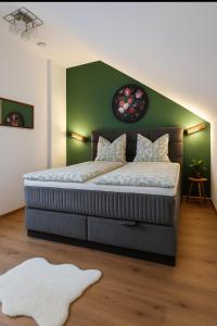 una camera da letto con un letto grande con una parete verde di Dimi Living Oberhausen & mit Küche a Oberhausen