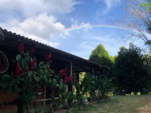 a rainbow in the sky over a house with plants at CATEDRAL THE ROCK CAMPING in Presidente Figueiredo