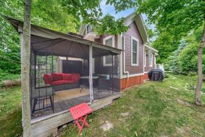 a screened in porch with a red couch on a house at The Firefly - 6 Chipmunk in Cherry Valley