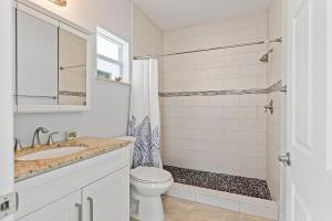 a bathroom with a toilet and a sink and a shower at Tipsy Turtle - Waterfront Pool Home, Direct Atlantic Access! in Marathon