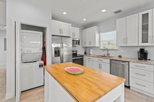 a kitchen with white cabinets and a wooden counter top at Tipsy Turtle - Waterfront Pool Home, Direct Atlantic Access! in Marathon