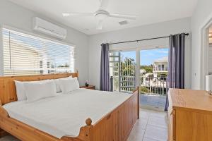 a bedroom with a bed and a large window at Tipsy Turtle - Waterfront Pool Home, Direct Atlantic Access! in Marathon
