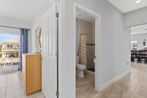 a white bathroom with a toilet and a balcony at Tipsy Turtle - Waterfront Pool Home, Direct Atlantic Access! in Marathon