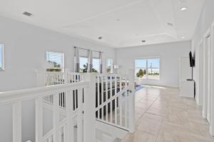 a white hallway with a staircase in a house at Tipsy Turtle - Waterfront Pool Home, Direct Atlantic Access! in Marathon