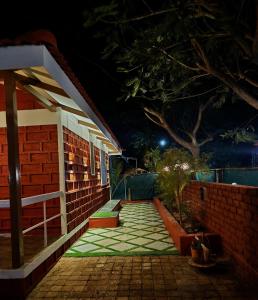 a night view of a brick building with a patio at Gulmohar Villa tamhini ghat, Kolad Rafting 
