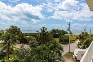 a view of the ocean from the balcony of a house at Tipsy Turtle - Waterfront Pool Home, Direct Atlantic Access! in Marathon